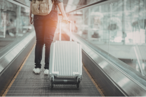 Turista bőröndöt húz a repülőtéren.