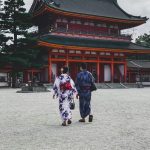 Egy fiatal japán pár jukata öltözékben sétál egy szentély előtt, Japán